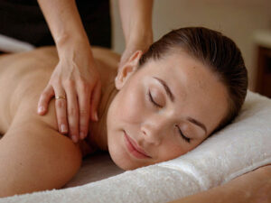 Woman receiving massage therapy by a Massage Therapist.